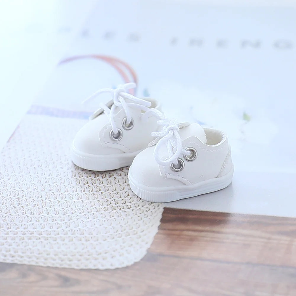 White baby shoes on a textured surface with a blurred background