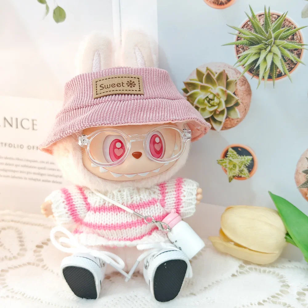 Toy figure wearing a pink hat and sweater with decorative plants in the background