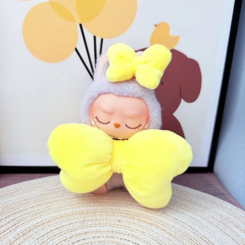 Plush toy with yellow bow on a textured surface