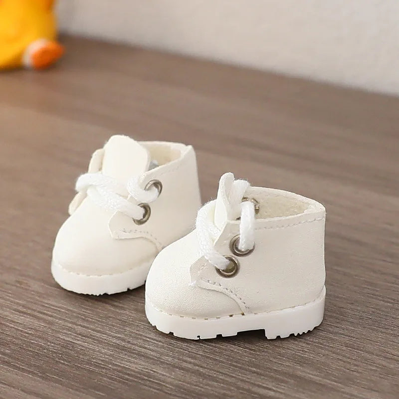 Pair of white baby boots on a wooden floor