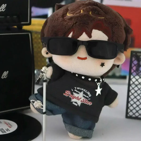 Plush toy with sunglasses and a black hoodie in front of a colorful background