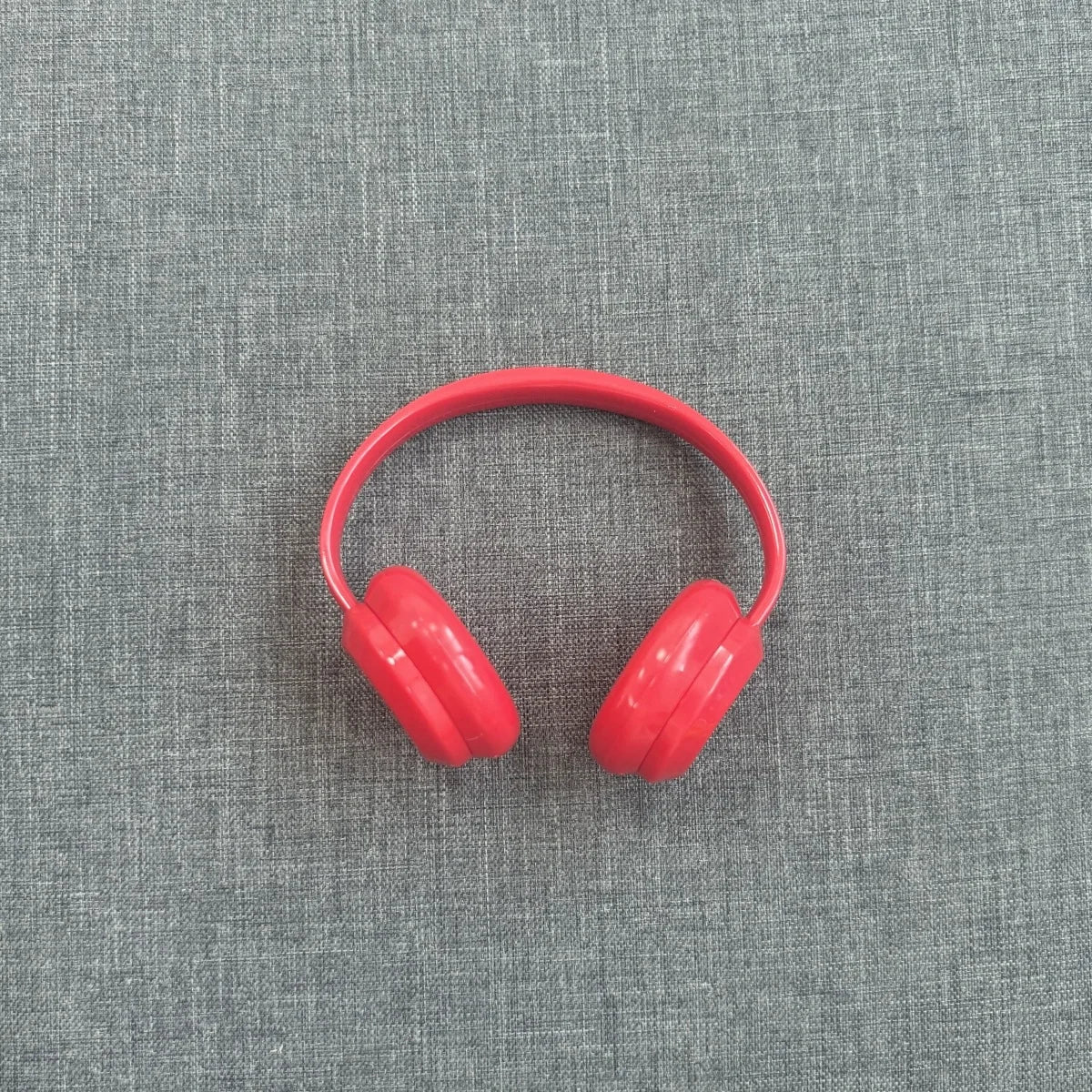 Red headphones on a gray textured background