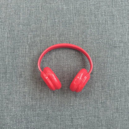 Red headphones on a gray textured background