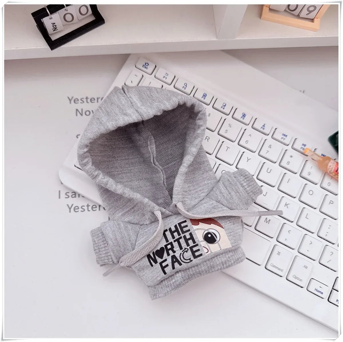 Gray baby hoodie with 'The North Face' logo on a keyboard