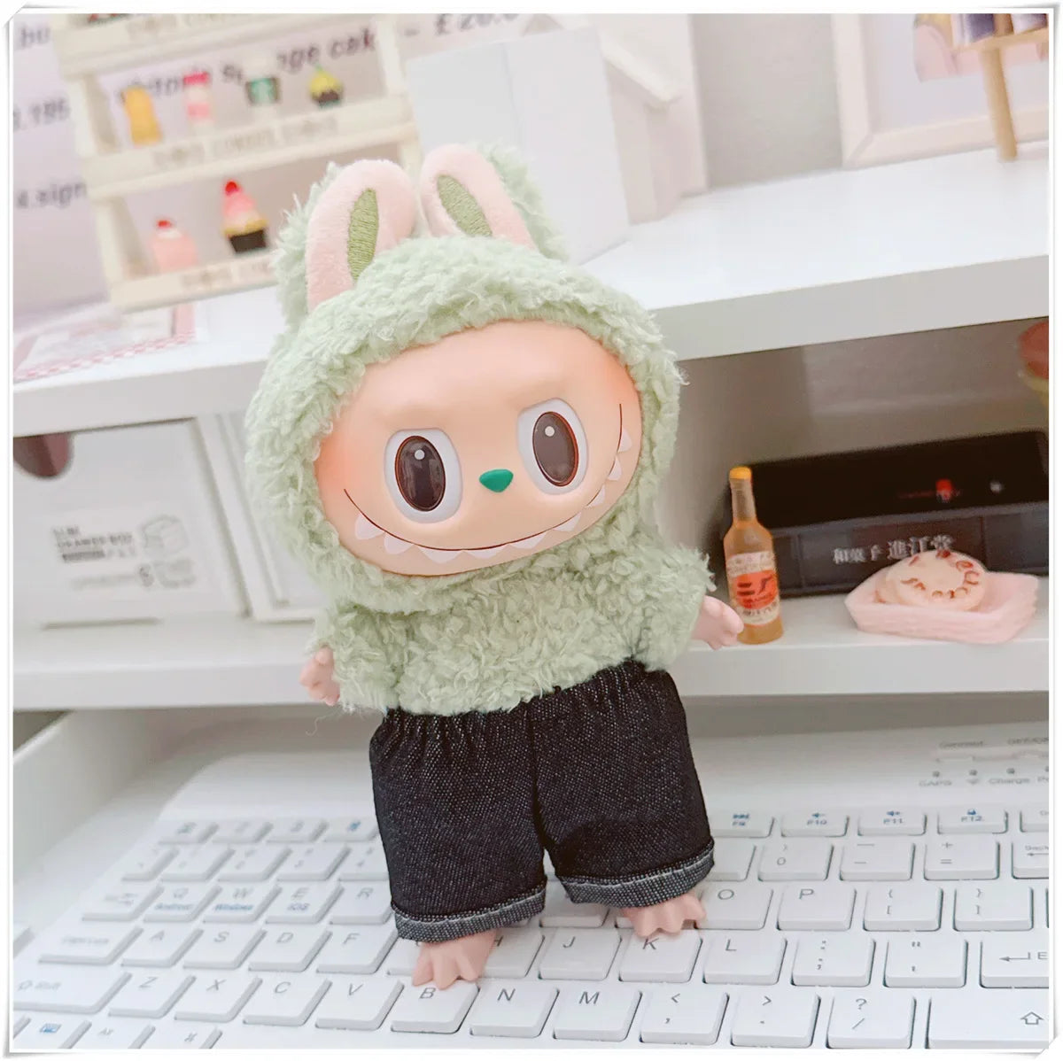 Toy figure with a green hood and black pants sitting on a keyboard