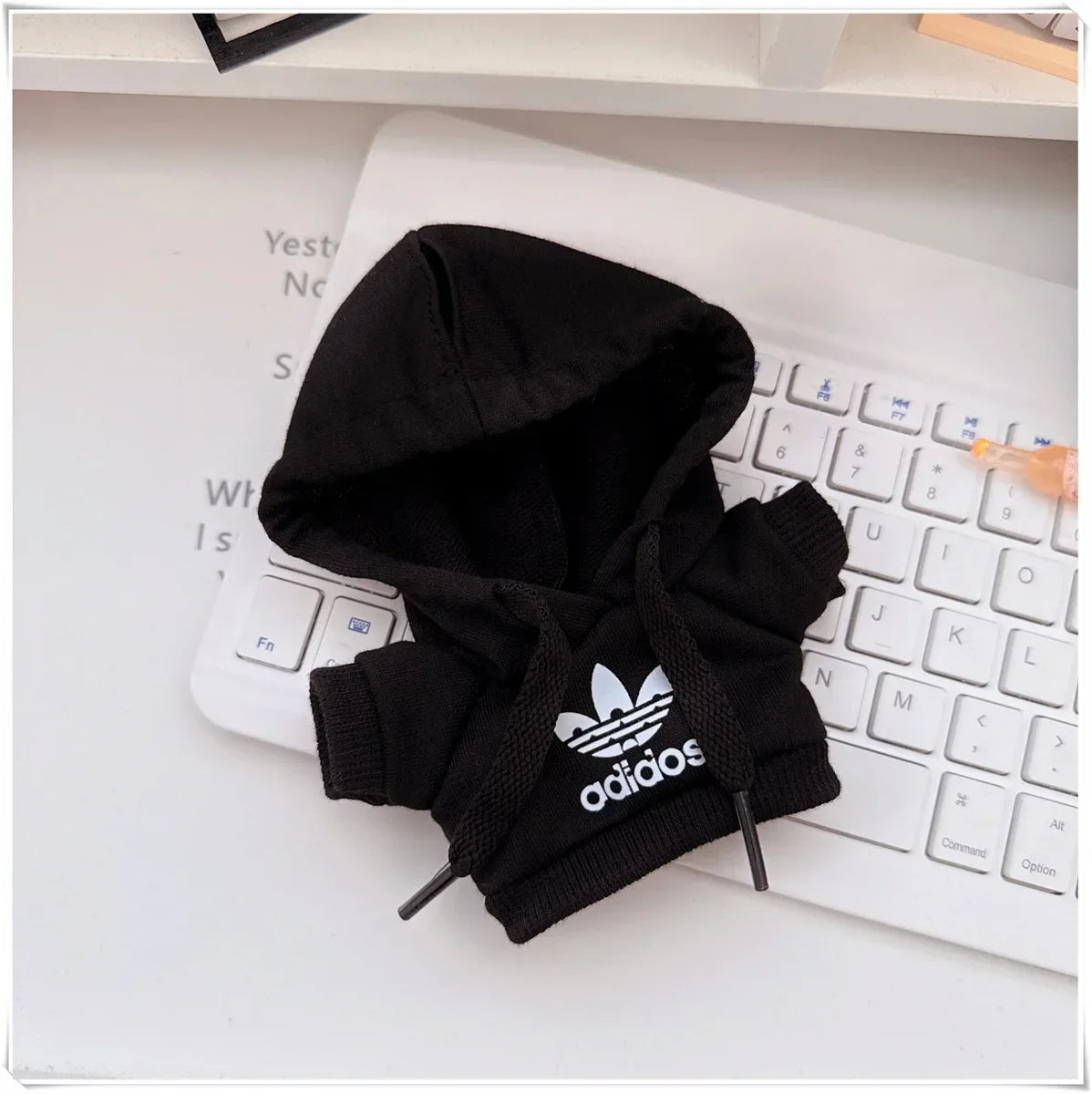 Black Adidas hoodie on a white keyboard