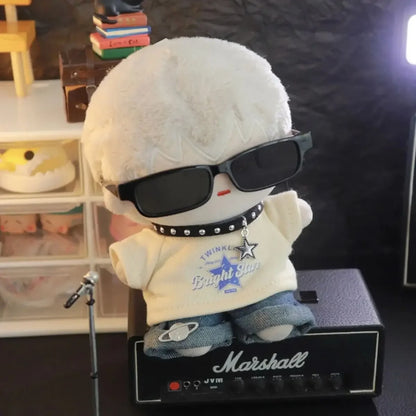 Plush toy with sunglasses and a shirt on top of a Marshall amplifier