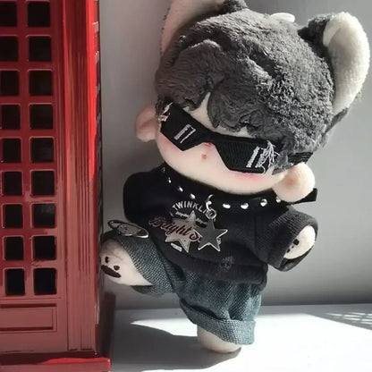 Plush toy with sunglasses and black outfit leaning against a red crate.