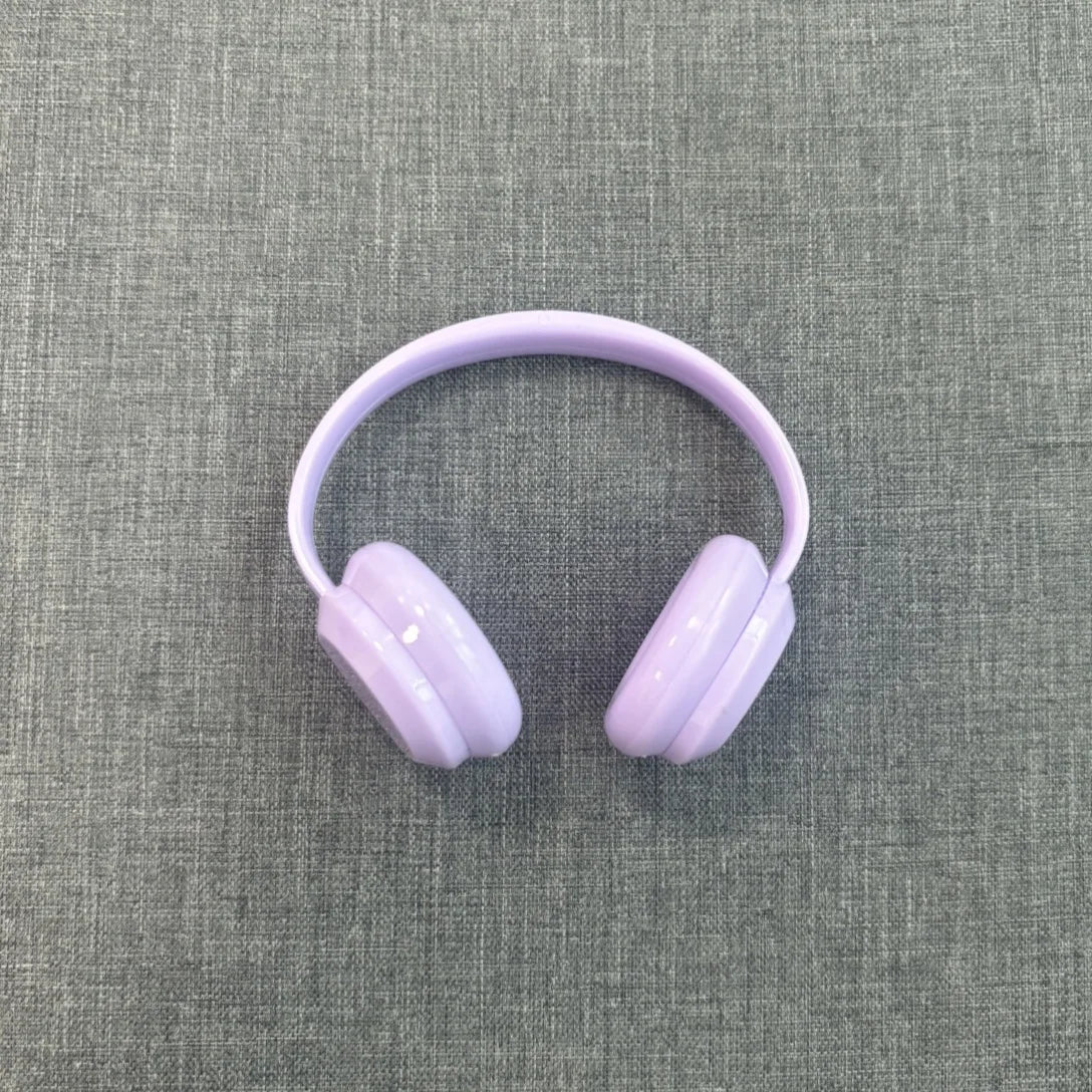 Purple headphones on a gray textured background