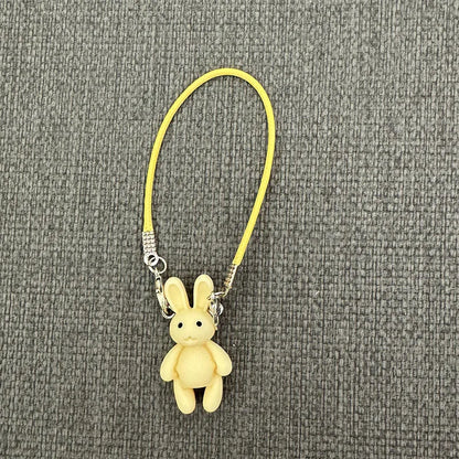 Yellow plush bunny keychain on a gray textured background