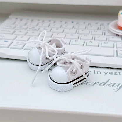 White baby sneakers with black stripes on a white surface