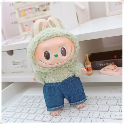 Plush toy with a green outfit and blue pants standing on a keyboard