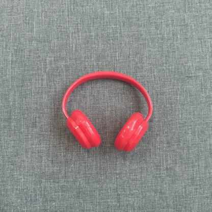 Red headphones on a gray textured background