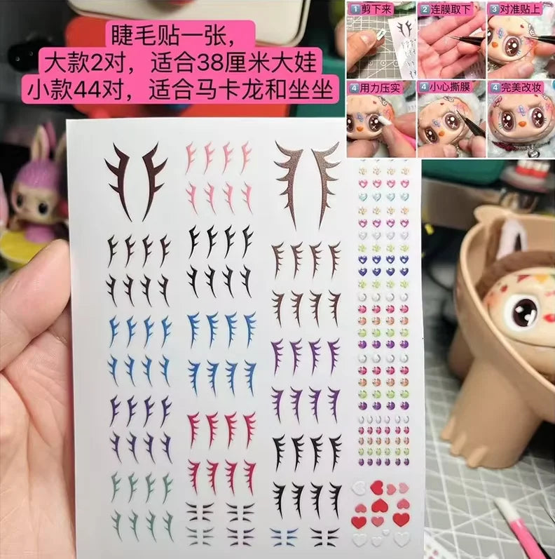 Eyelash stickers with various designs on a white card, held by a hand.
