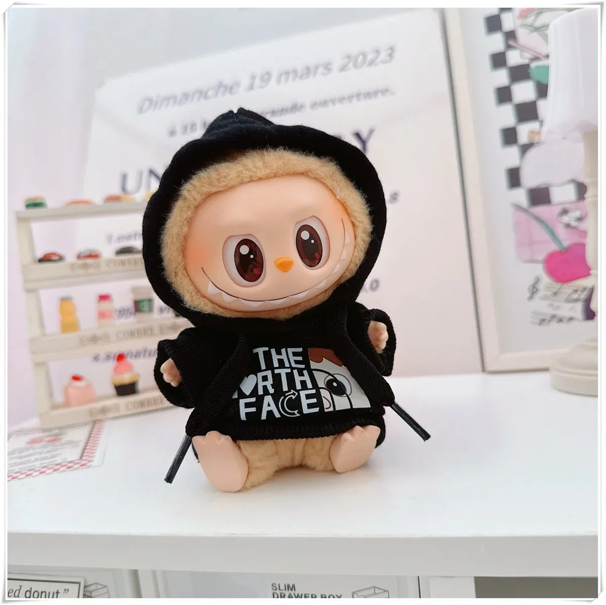 Plush toy with a black hoodie featuring 'The North Face' logo on a white surface.