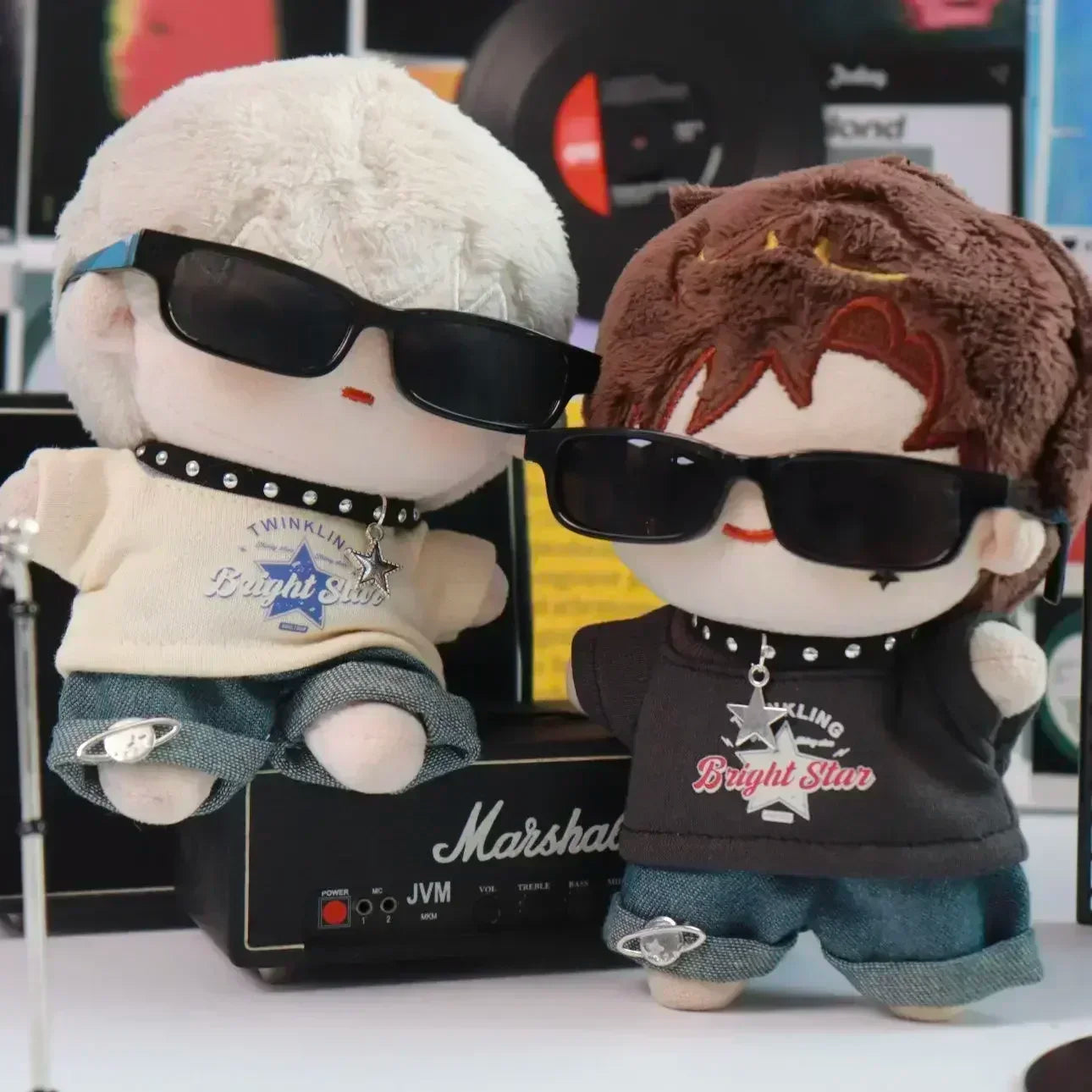 Two plush toys wearing sunglasses and outfits in front of a Marshall amplifier.