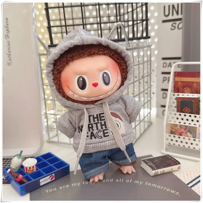 Plush toy with a gray hoodie and blue pants on a surface with text