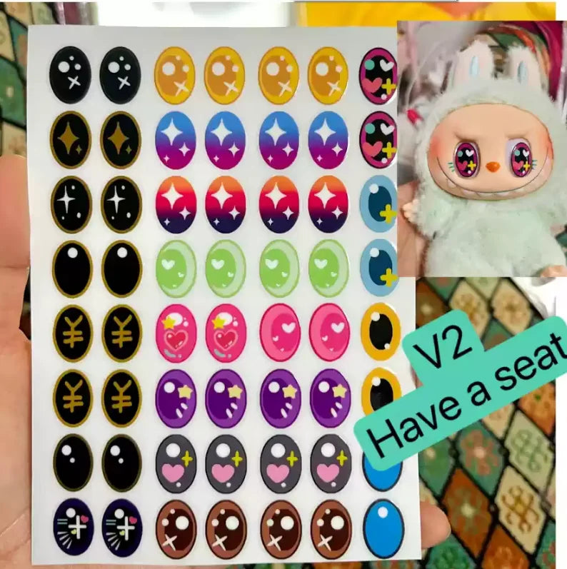 Sheet of colorful oval stickers with a toy figure in the corner labeled 'V2 Have a seat'.