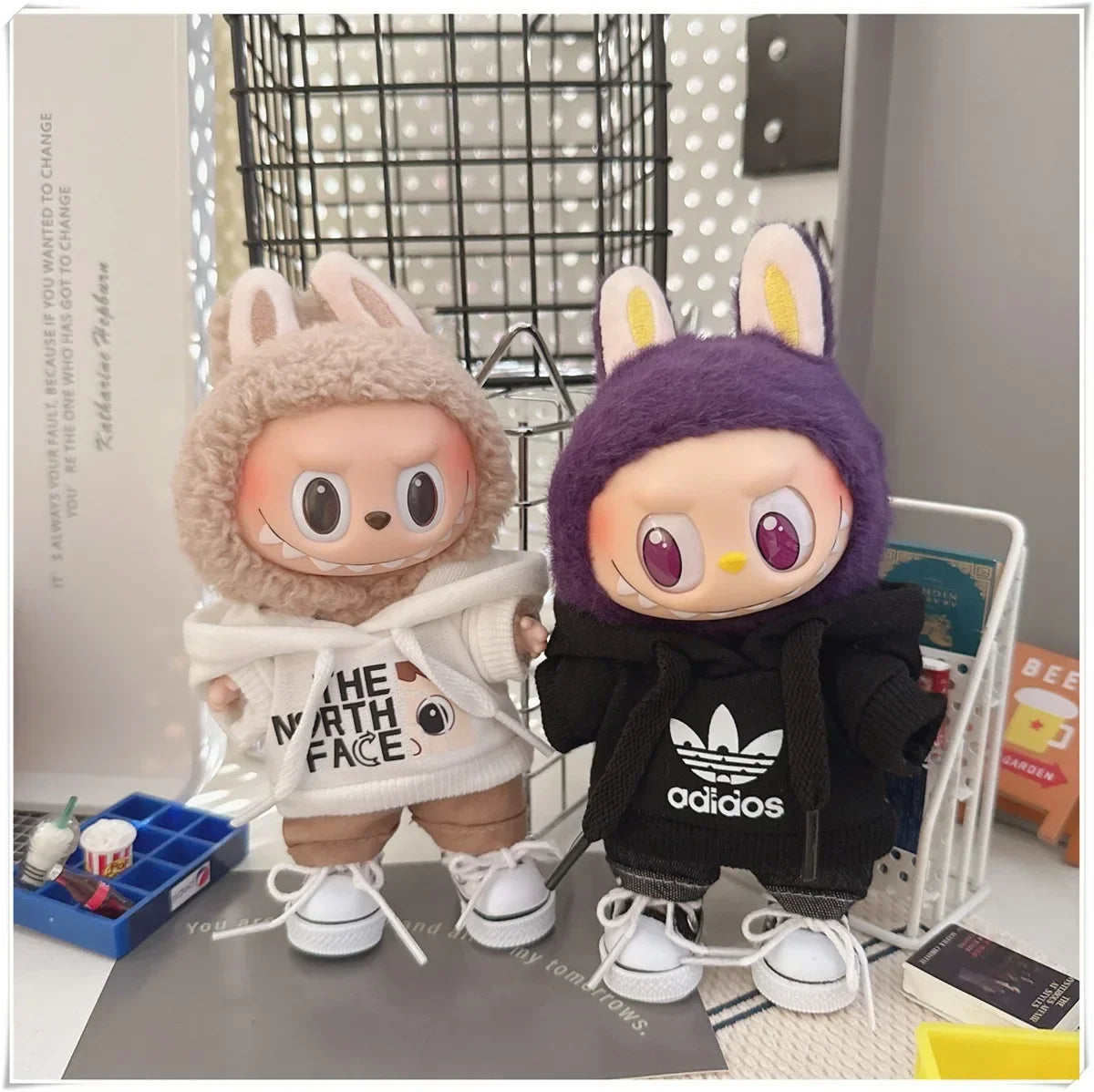 Two plush toys wearing hoodies with visible brand logos on a surface.