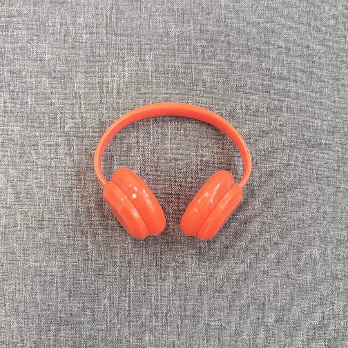 Orange headphones on a gray textured background