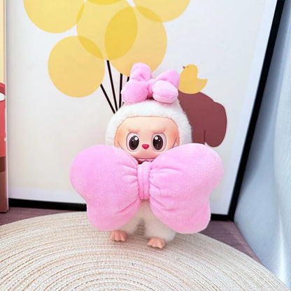 Plush toy with pink bow and white outfit on a surface with yellow balloons in the background