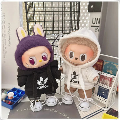 Two plush toys wearing Adidas outfits on a surface with a blurred background