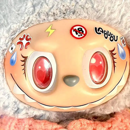 Toy with red eyes and various stickers on a textured surface