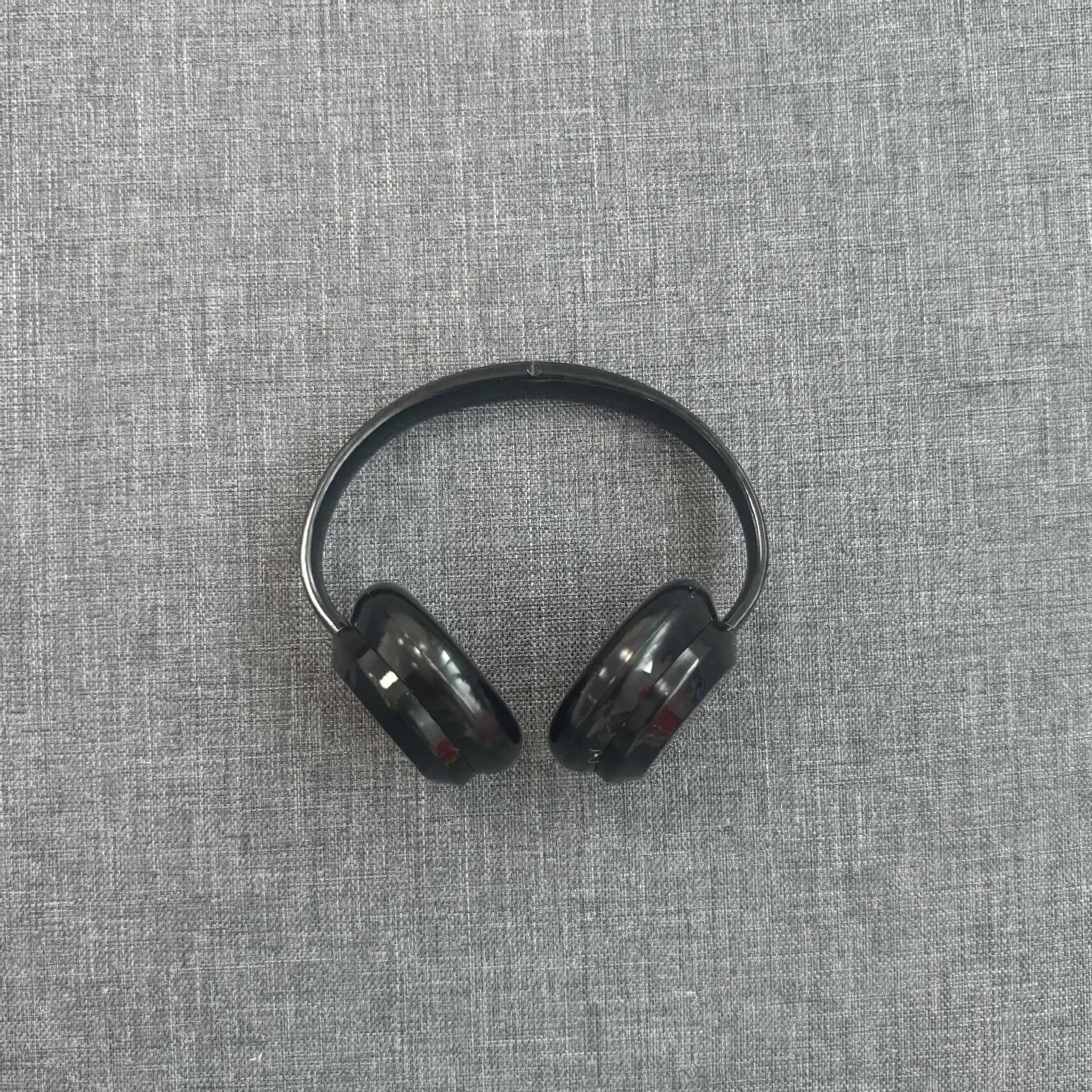 Black wireless earbuds on a gray textured surface
