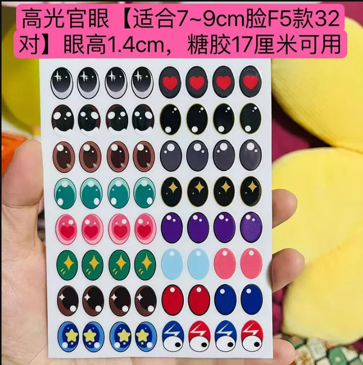 Sheet of colorful eye stickers held by a hand with a multicolored background