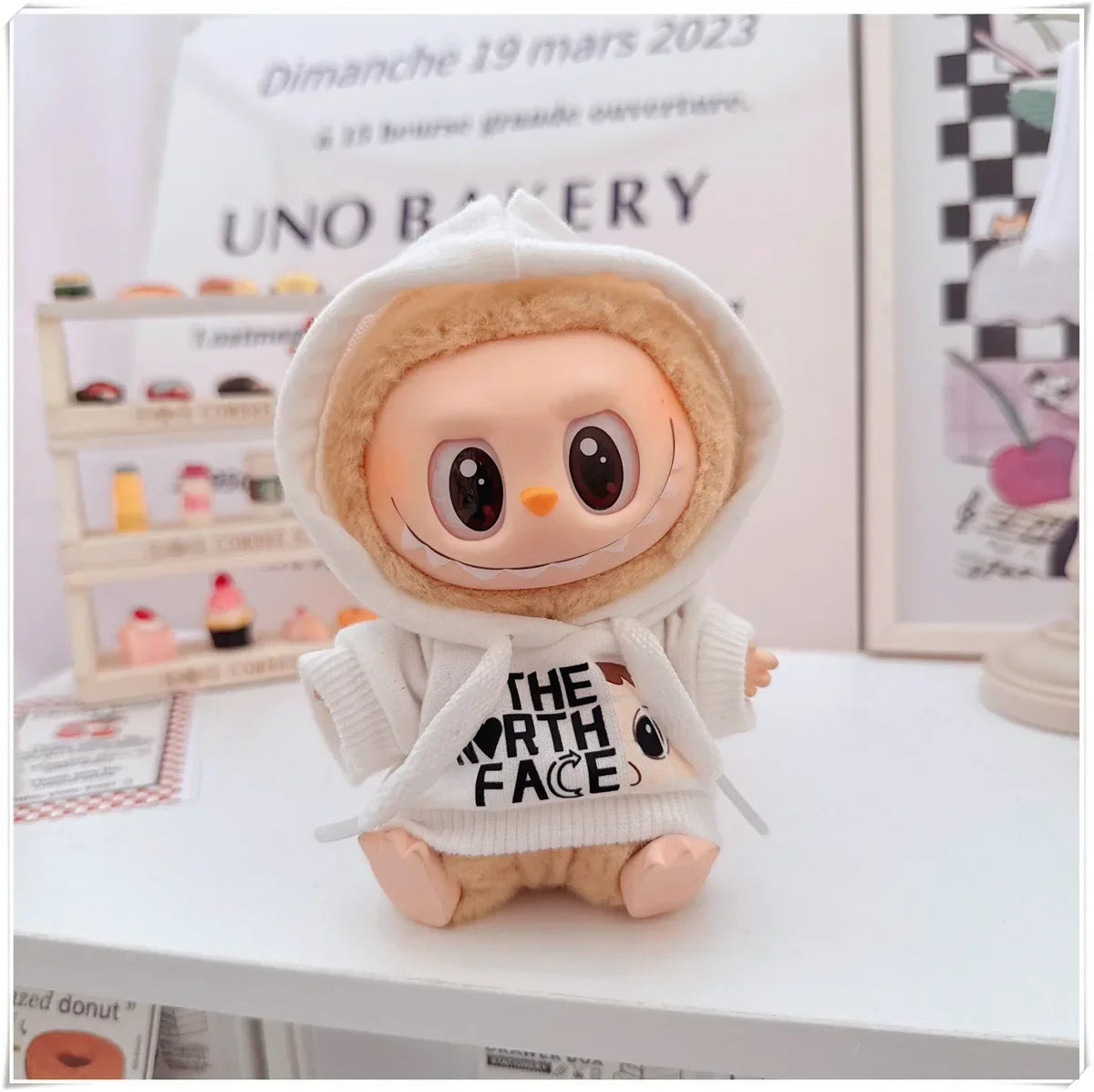 Plush toy with a hoodie featuring 'The North Face' logo on a white surface.