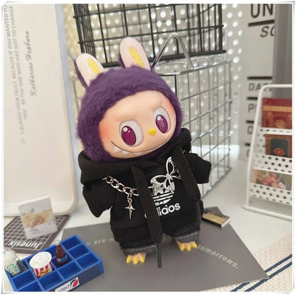 Plush toy with a black hoodie featuring a brand logo on a desk.